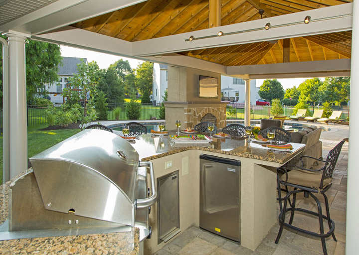 outdoor kitchen with multiple appliances and guest seating