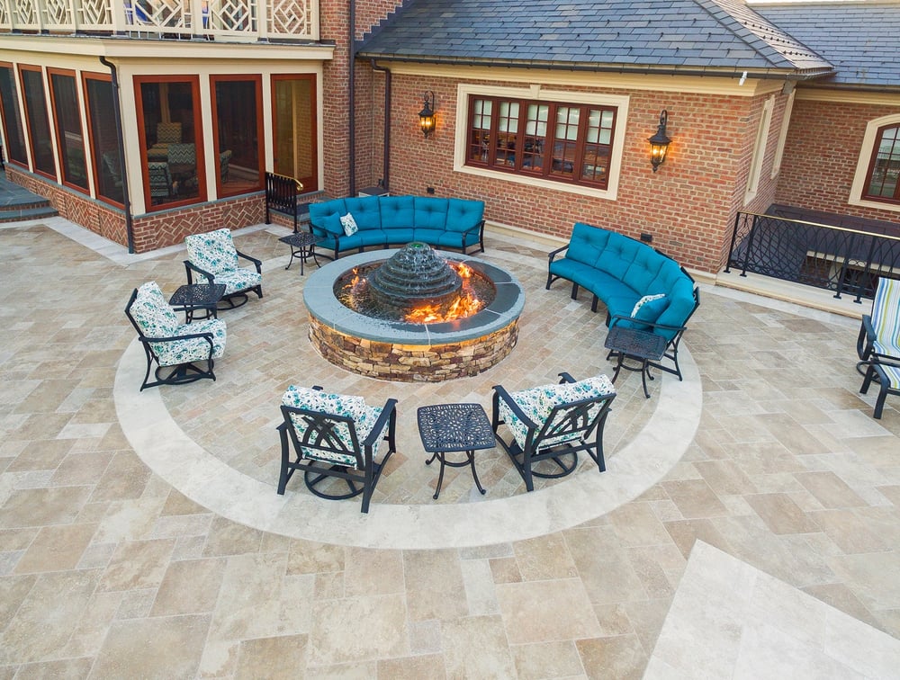 large fire pit fountain on patio with chairs for guests