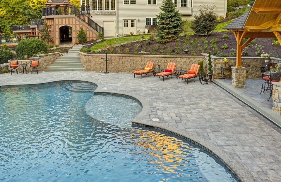 Pool patio with pavilion, steps, and retaining wall